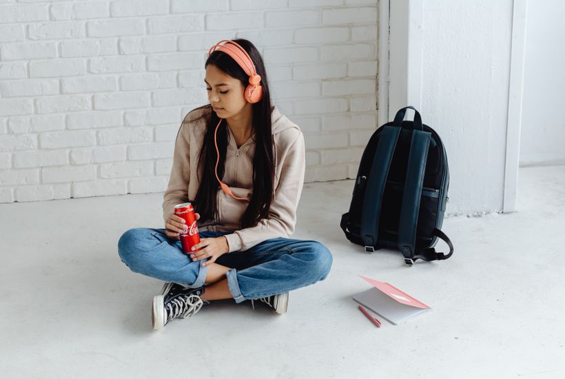 Young adult sitting near a sunlit window reflecting on managing gen z anxiety and stress.